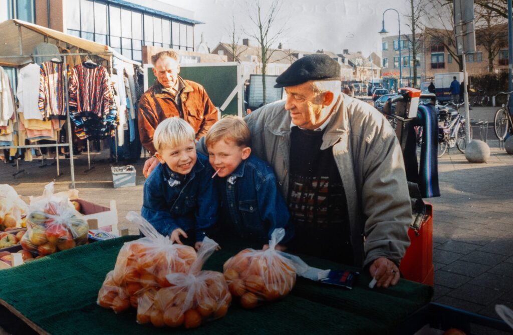 Beverwijkse ondernemer Jacques Davidson, afgebeeld met zijn 2 kleinzoons bij de fruitkraam op de markt.
