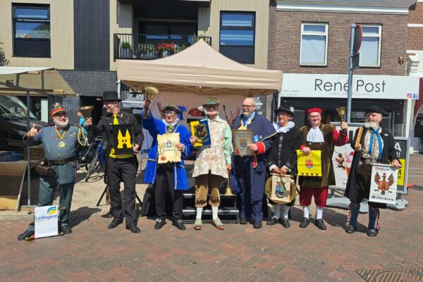 Groepsfoto bij het podium op de weekmarkt
