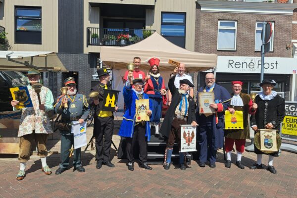 Groepsfoto bij het podium op de weekmarkt met jury